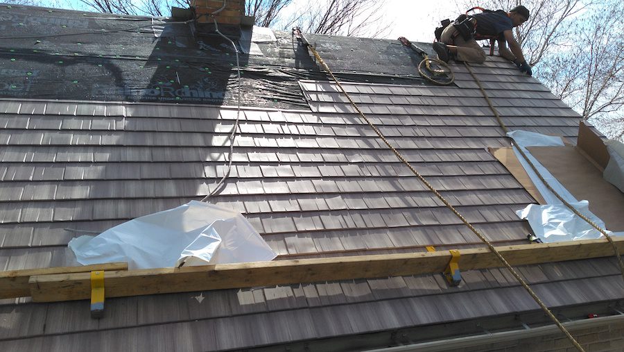 Workers installing cedar composite roofing